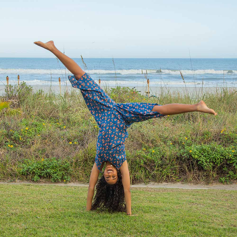 Girl doing cartwheel in a cute jumpsuit