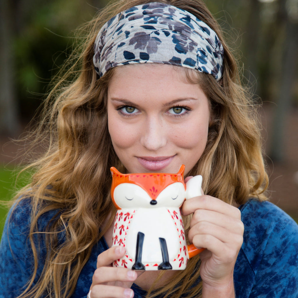 Girl holding a Natural Life mug shaped like a fox