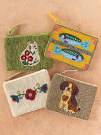 Four beaded pouches with different designs on a brown background