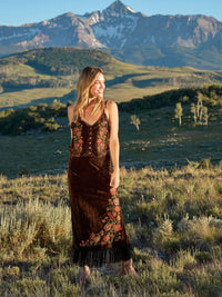 girl standing in the mountains wearing a matching brown velvet set