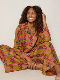 Woman wearing a floral pajama set against a plain background