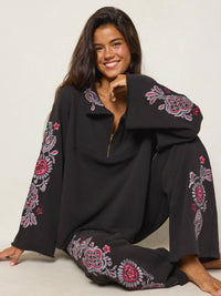 girl sitting in an embroidered black sweat set