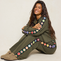 girl sitting on floor with matching crocheted trim sweatsuit