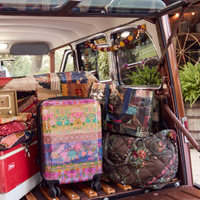 luggage and other bags in the trunk of a vintage car at a cabin