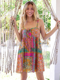 Girl in tie-front colorful dress on a porch